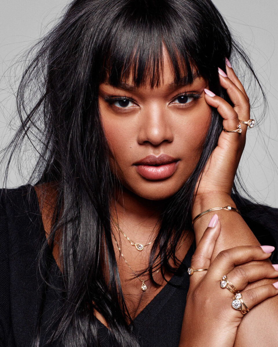 Portrait of a woman with black hair and bangs wearing pandora rings and bracelets as jewelry