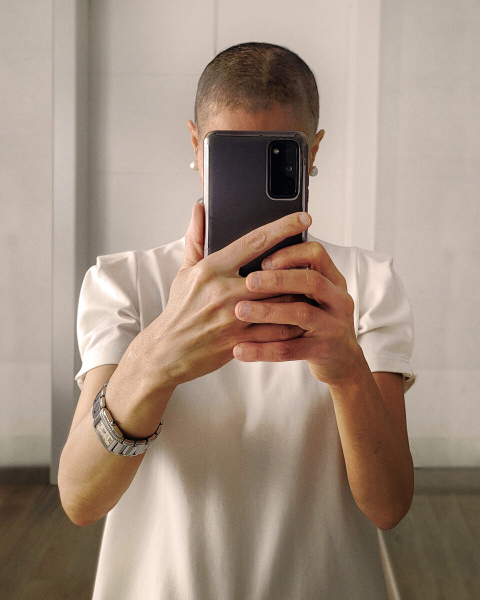 A woman taking a photo of herself in front of the mirror