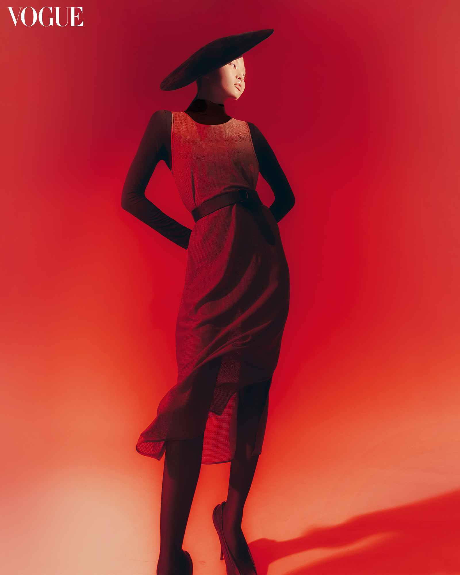 A woman in a red dress and black hat