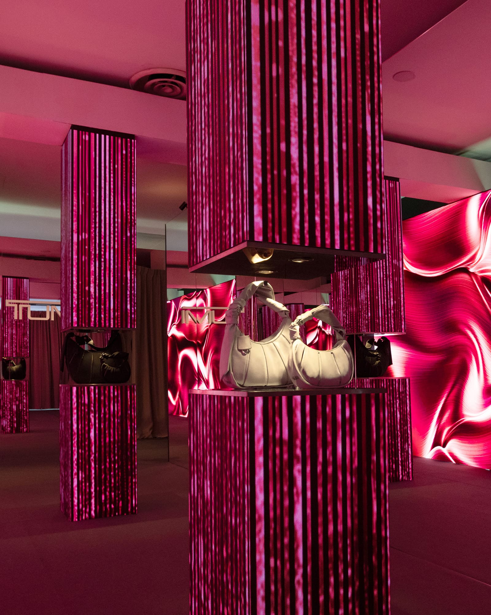 An pink and red LED display of the TUMI Asra collection